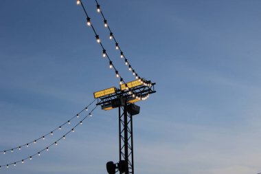Fener bayramı ışıklandırması ve gece gökyüzüne karşı parlayan ampullerle süslenmiş bir çelenk.