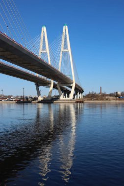 Kablolu köprü sütunlarının ve tematik bir bayrak için suda refleksleri olan otoyolun bir kısmının görüntüsü