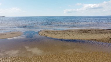 Körfezdeki balık sürülerinin havadan görünüşü ve güneşli bir bahar gününde doğal bir arkaplan için suyun mavi genişliği ufka kadar uzanıyor.