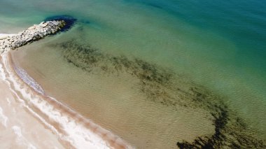 Kumlu sahilin havadan görünüşü ve sığ gök mavisi güney denizi doğal bir arka plan.