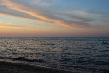 Gün batımında kırmızı sarı çizgilerle bulutlu bir gökyüzü. Gökyüzü dokusu, soyut doğa arkaplanı