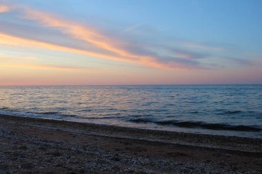 Akşamları gökyüzü, denizin üzerinde renkli bulutlarla