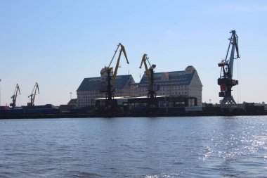 Kalininingrad, Rusya - 8 Eylül 2021. Su manzarası, iskele vinçlerinin siluetleri, konteynır alanları ve Kaliningrad limanının binaları