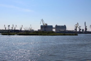 Kalininingrad, Rusya - 8 Eylül 2021. Su manzarası, iskele vinçlerinin siluetleri, konteynır alanları ve Kaliningrad limanının binaları