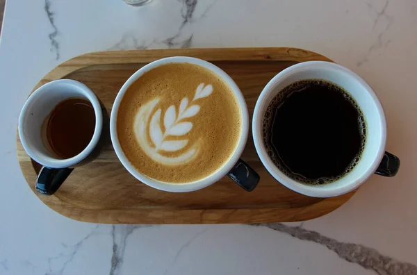 コーヒーセット エスプレッソ カプチーノ 白い大理石のテーブルの上のコーヒー フロントトップ写真 — ストック写真