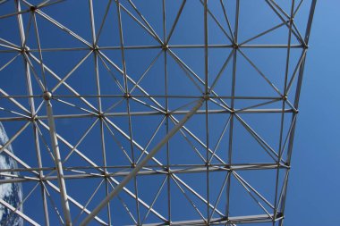 Mavi gökyüzüne karşı bir dalga şeklinde metal çerçeve