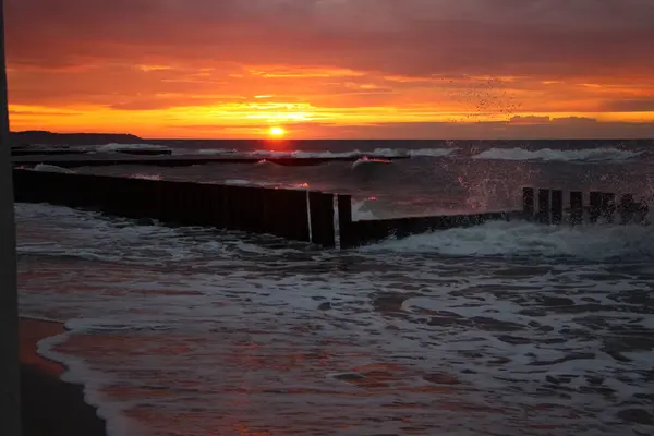 在暴风雨天气里 美丽的落日在海面上 浪花和泡沫上都有红色的反光 — 图库照片