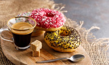 Masanın üstünde renkli, lezzetli kahvaltı çörekleri ve yanında kahve var..