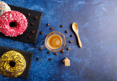 Masanın üstünde renkli, lezzetli kahvaltı çörekleri ve yanında kahve var..