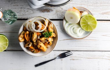 Deniz ürünleri aperatifleri sirke içinde marine edilmiş taze midyeler ve bir kasede soğan. Üst alt görünüm.