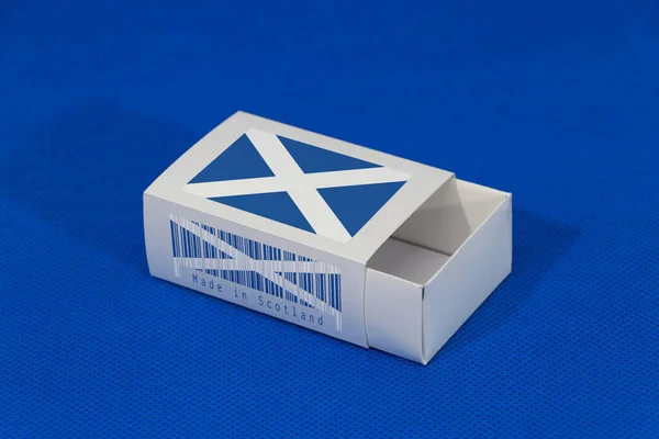 苏格兰国旗白色盒子上有条形码和蓝色背景国旗的颜色 纸包装用于搭配或产品 苏格兰出口贸易的概念 — 图库照片
