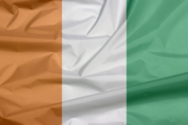 Fildişi Sahili 'nin kumaş bayrağı. Fildişi Sahili arkaplan kırışıklığı, turuncu, beyaz ve yeşil dikey üç renkli.