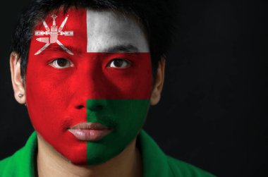 Siyah arka planda Umman 'ın bayrağını taşıyan bir adamın portresi. Spor ya da milliyetçilik kavramı.