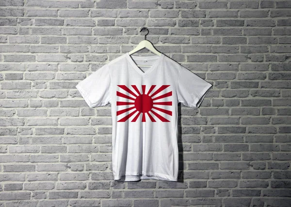 The Imperial Japanese Army war flag on shirt and hanging on the wall with brick pattern wallpaper, the rising sun flag on shirt.