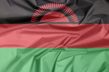 Malavi 'nin kumaş bayrağı. Malawi bayrak arkaplan kırışıklığı, siyah kırmızı ve yeşil; siyah şeritli kırmızı yükselen bir güneş ile şarj.