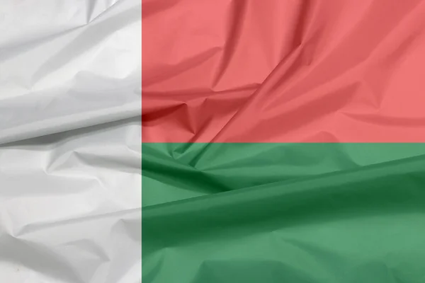 マダガスカルの生地の旗 マダガスカルの旗の背景の折り目 ホイスト側に白の垂直バンドと赤と緑の2つの水平バンド — ストック写真