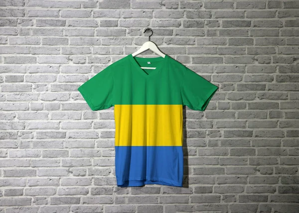 Gabão Bandeira Camisa Pendurado Parede Com Papel Parede Padrão Tijolo — Fotografia de Stock