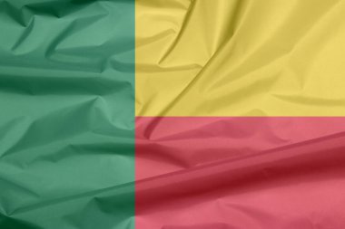Benin 'in kumaş bayrağı. Benin bayrak arka plan kırışıklığı, yeşil dikey şeritli sarı ve kırmızı bir yatay bicolor.