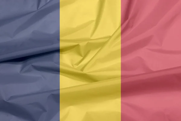 Fabric flag of Chad. Crease of Chadian flag background, A vertical tricolor of blue, gold, and red.