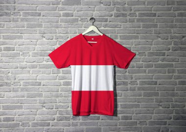 Gömlekte kırmızı ve beyaz Avusturya bayrağı ve duvarda tuğla desenli duvar kağıtlarıyla asılı..