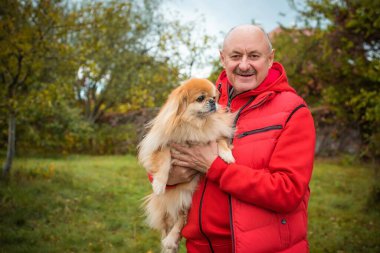 Kırmızı küçük köpeği olan yaşlı bir adam emekli, yaşlı insanların yaşam tarzı.