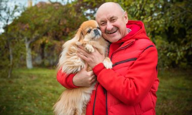 Kırmızı küçük köpeği olan yaşlı bir adam emekli, yaşlı insanların yaşam tarzı.