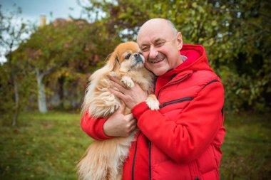 Kırmızı küçük köpeği olan yaşlı bir adam emekli, yaşlı insanların yaşam tarzı.