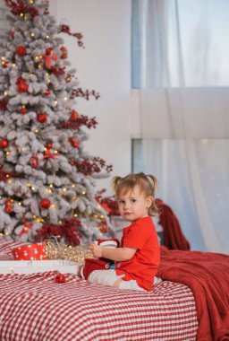 Kış tatili konsepti. İlham ve peri zamanı. Noel ağacının yanında bir çocuk. Çok hoş sıcak tatil günleri, büyülü Noel zamanı.