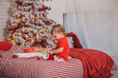 Kış tatili konsepti. İlham ve peri zamanı. Noel ağacının yanında bir çocuk. Çok hoş sıcak tatil günleri, büyülü Noel zamanı.