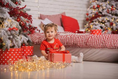 Kış tatili konsepti. İlham ve peri zamanı. Noel ağacının yanında bir çocuk. Çok hoş sıcak tatil günleri, büyülü Noel zamanı.