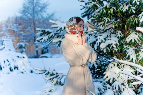 美丽的欧洲时尚女性在冬天 头戴头巾 背对着树木 童话般的冬天 古旧的红唇和明亮的眼睛 下雪了 — 图库照片