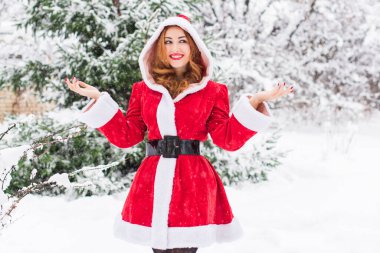 Mutlu Noeller ve mutlu Noeller! Karlı bir günde Noel Baba kız. Bebek dışarıda oyundan zevk alıyor. Park arka planında portre yapan kadın.