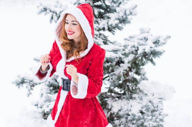 Mutlu Noeller ve mutlu Noeller! Karlı bir günde Noel Baba kız. Bebek dışarıda oyundan zevk alıyor. Park arka planında portre yapan kadın.