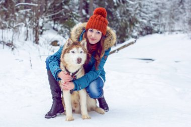 Kış ve Noel 'le ilgili bir şey. Kış, hayallerin gerçekleşmesi için büyülü bir zamandır. Karlı kış manzarasında güzel bir kadın portresi. Güzel bir kadınla Sibiryalı Husky Dog 'un sihirli anları kutlu olsun.