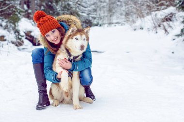Kış ve Noel 'le ilgili bir şey. Kış, hayallerin gerçekleşmesi için büyülü bir zamandır. Karlı kış manzarasında güzel bir kadın portresi. Güzel bir kadınla Sibiryalı Husky Dog 'un sihirli anları kutlu olsun.