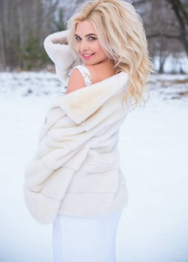 Tatil günleri, Noel kış zamanı. Zarif elbiseli ve kürklü bir kadın. Şık elbiseli bir kız, kadın modası konsepti, karlı havada sokakta poz veren.