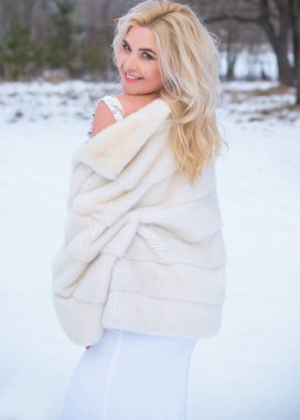 Tatil günleri, Noel kış zamanı. Zarif elbiseli ve kürklü bir kadın. Şık elbiseli bir kız, kadın modası konsepti, karlı havada sokakta poz veren.