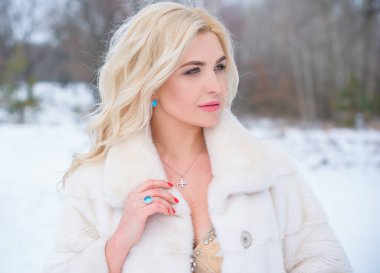 Tatil günleri, Noel kış zamanı. Zarif elbiseli ve kürklü bir kadın. Şık elbiseli bir kız, kadın modası konsepti, karlı havada sokakta poz veren.