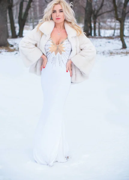 クリスマス冬時間 エレガントなドレスや毛皮のコートの屋外で女性 ファッショナブルな服の女の子 女性のファッションの概念は 雪の天候で通りにポーズ — ストック写真