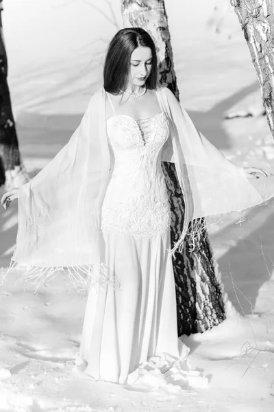 白いロングドレスの女性 冬の雪の上に 素朴なスタイルでウェディングドレスに身を包んだかなり若いエレガントでセクシーな女性 冬の魔法の結婚式 — ストック写真
