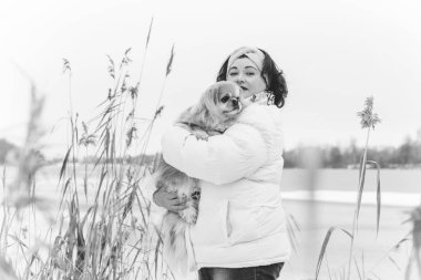 Ayrıca kışın parkta köpeğiyle gezen zarif bir kadın köpek sever kadın yaşam tarzı, evcil hayvanla sihirli soğuk Noel zamanı, evcil hayvan hayatı.