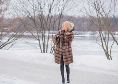  Doğada kürk giymiş zarif bir bayan, sonbahar - kış mevsimi, çekici görünümlü bir kadın