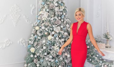 Kış tatilleri, kutlamalar ve insanlar konsepti - Noel arkaplanda zarif kıyafetler içindeki genç seksi kadın.