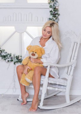 Kış tatilleri, kutlamalar ve insanlar konsepti - Noel arkaplanda zarif kıyafetler içindeki genç seksi kadın.