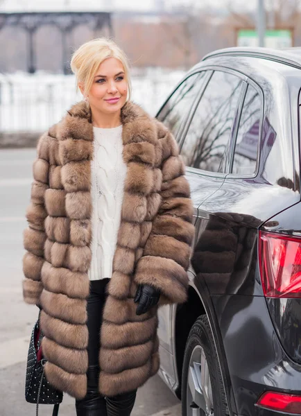 Nice elegant lady in fur coat at nature, autumn - winter season time, woman with attractive appearance