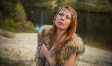 Kızıl saçlı İskandinav modern Viking kadın, ortaçağ atmosferi, kürk giymiş çekici orta yaşlı kadın.