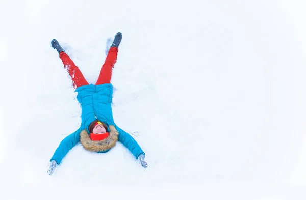 Вид Высоким Углом Счастливой Девушки Лежащей Снегу Двигающей Руками Ногами — стоковое фото