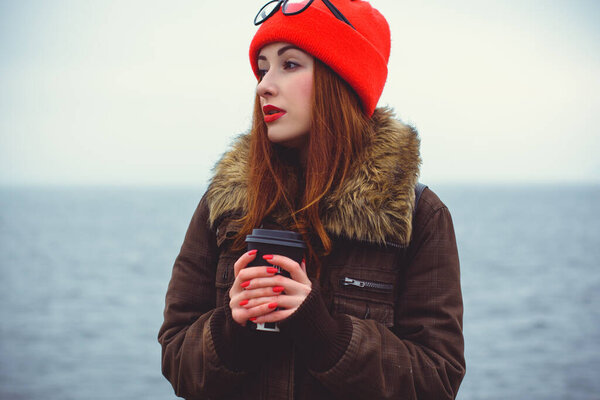 Philosophy woman hipster with good mood. Lifestyle young people or student. Girl with cup of coffee in America at cold weather