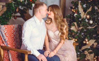  Noel hediyesi ile sürpriz yapan bir erkek ve kadının yeni yıl resmi. Noel 'i birlikte kutlayan çift. Güzel genç çift romantik bir yerde kutlama yapıyor..