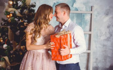 Noel hediyesi ile sürpriz yapan bir erkek ve kadının yeni yıl resmi. Noel 'i birlikte kutlayan çift. Güzel genç çift romantik bir yerde kutlama yapıyor..